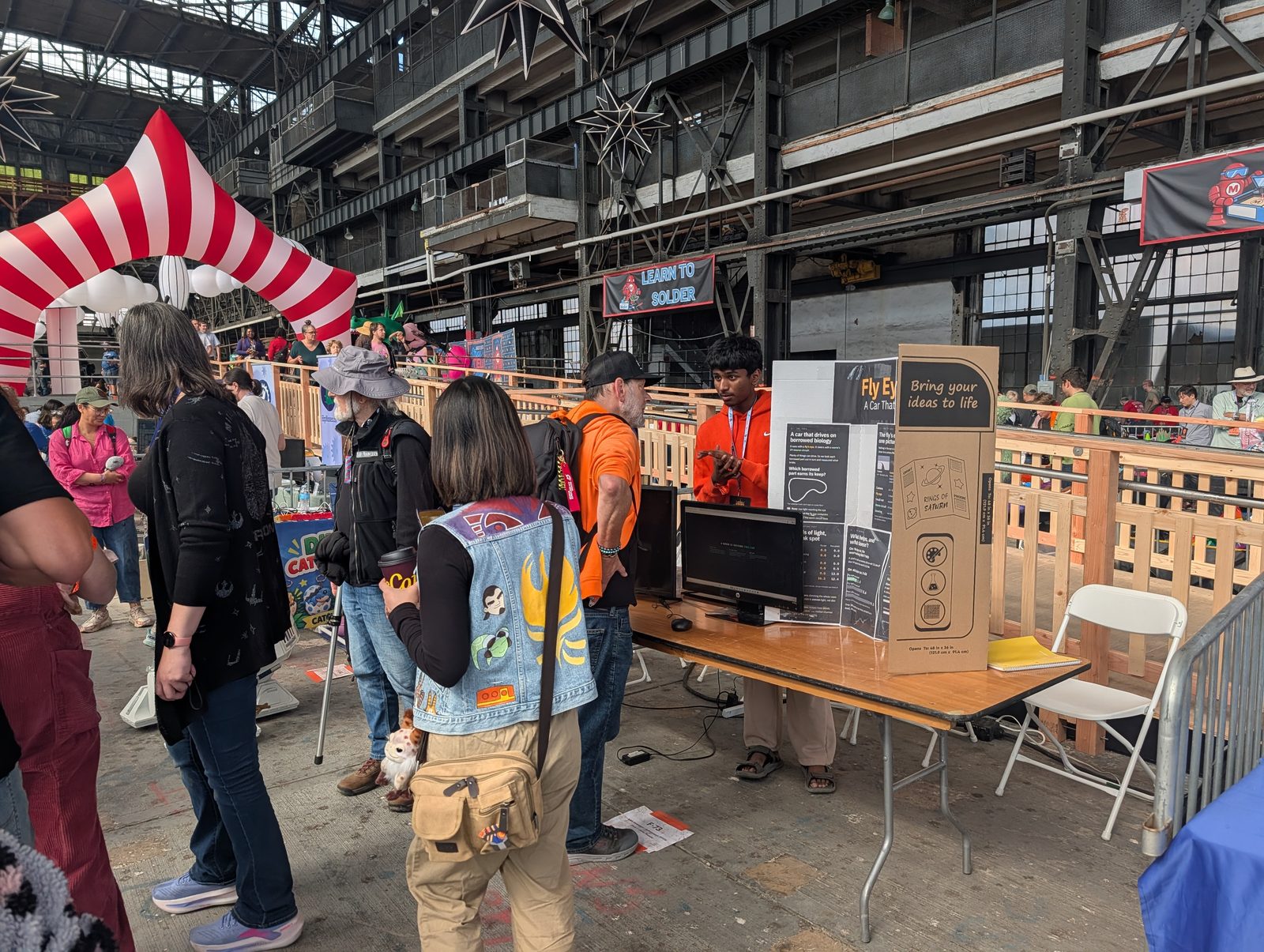 Visitors gathered at the AOST booth reading the poster